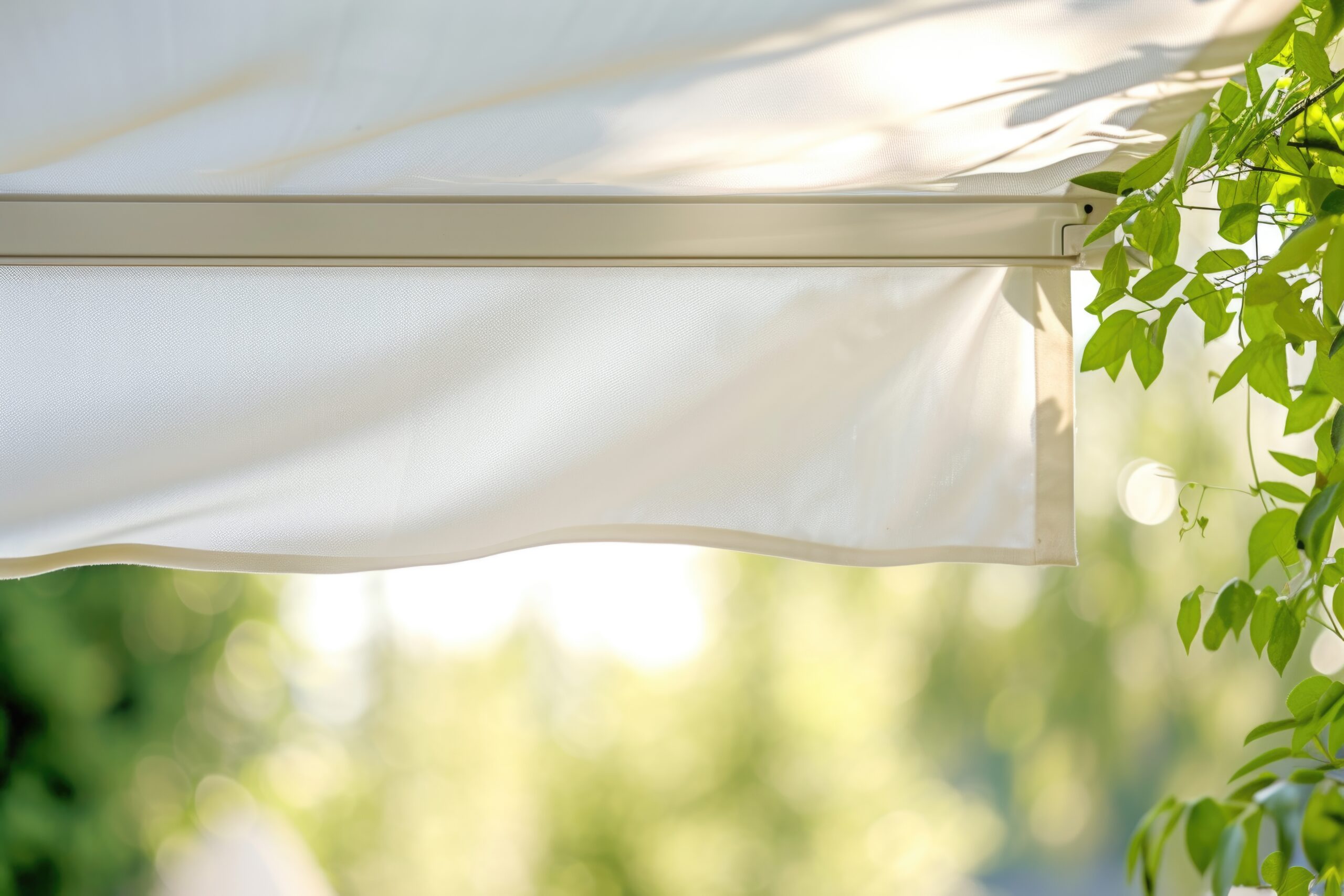 Détail d’un store-banne avec toile déployée protégeant une terrasse du soleil en été.